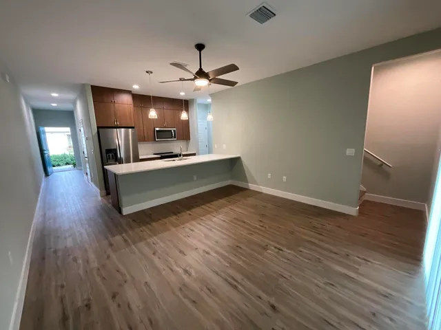 a view of living room with wooden floor and ceiling fan