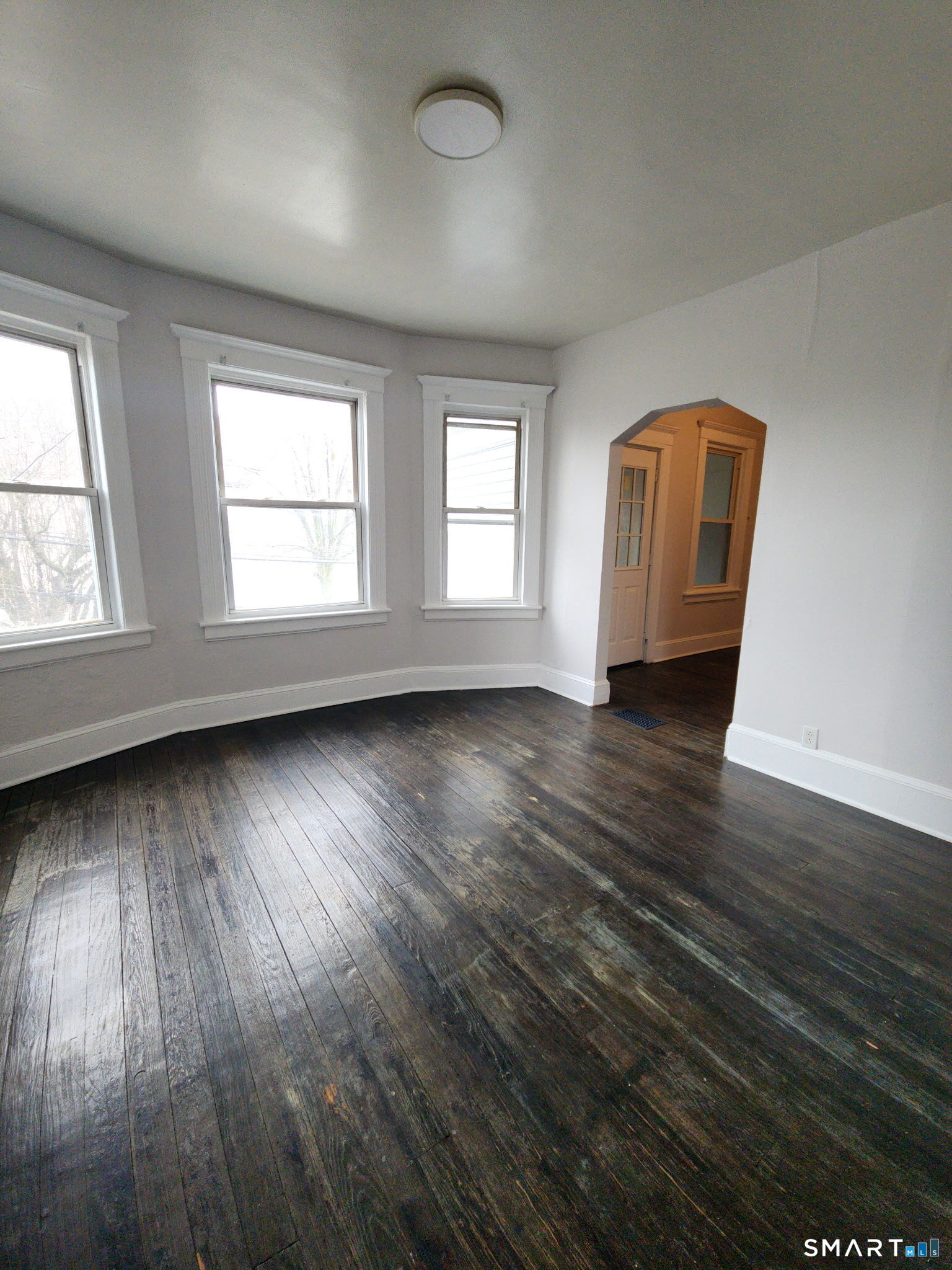 93-95 Baldwin Street, Unit 2 Bridgeport, CT 06607 - Photo 6 of 9 an empty room with wooden floor and windows