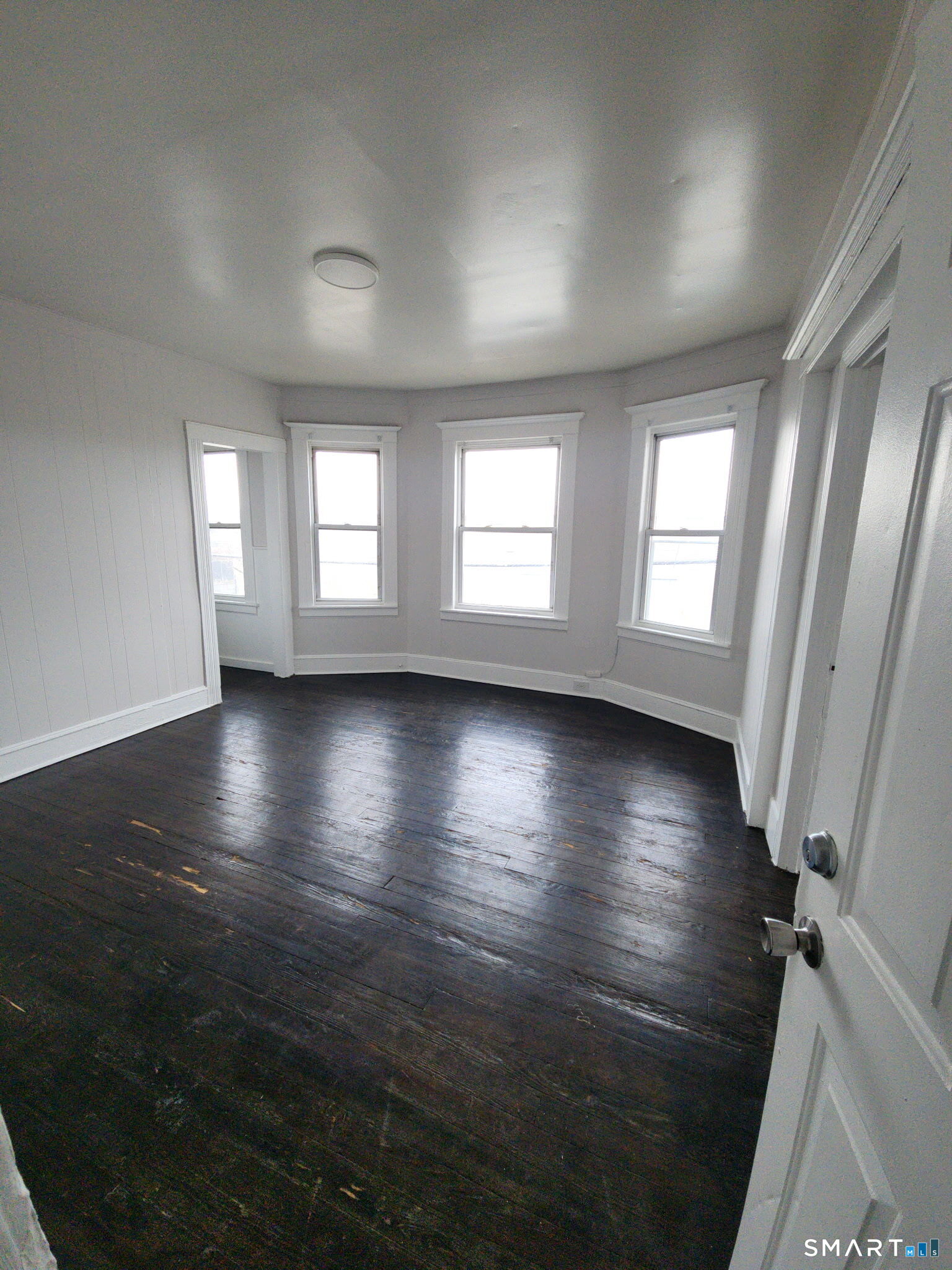 93-95 Baldwin Street, Unit 2 Bridgeport, CT 06607 - Photo 7 of 9 an empty room with wooden floor and windows