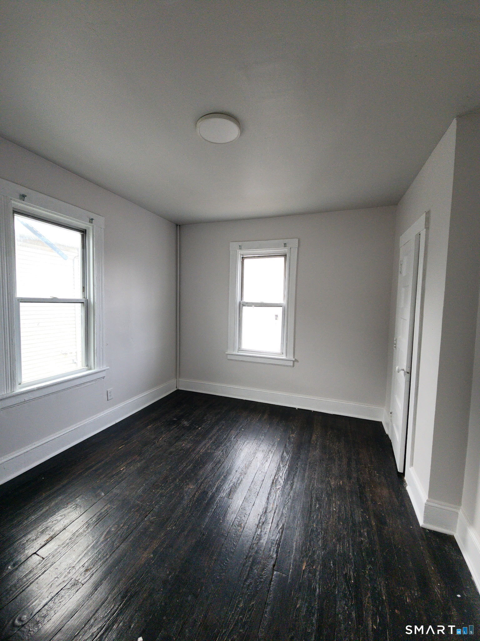 93-95 Baldwin Street, Unit 2 Bridgeport, CT 06607 - Photo 8 of 9 an empty room with wooden floor and windows