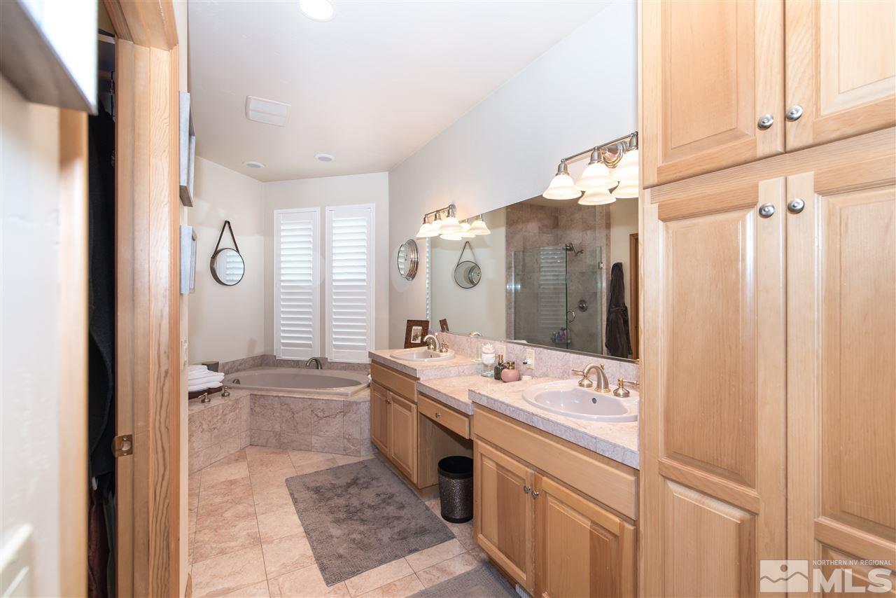 1199 Yates Lane Reno, NV 89509 - Photo 16 of 25 a spacious bathroom with a double vanity sink a mirror and a bathtub