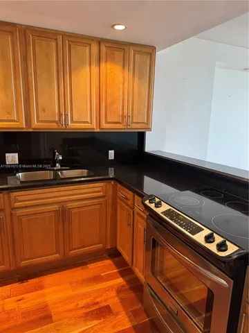 a kitchen with granite countertop cabinets and black appliances