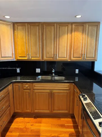 a kitchen with stainless steel appliances granite countertop a sink a stove and a microwave