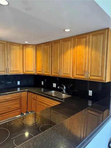 a kitchen with a sink a counter and a chair
