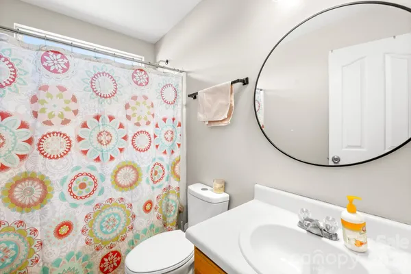 a bathroom with a sink toilet and a mirror