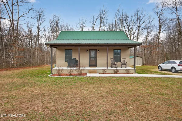 a view of a house with backyard and sitting area