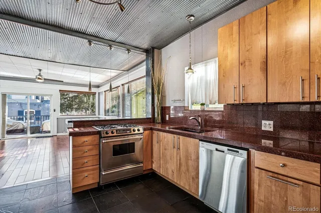 a kitchen with stainless steel appliances granite countertop a stove a sink and white cabinets