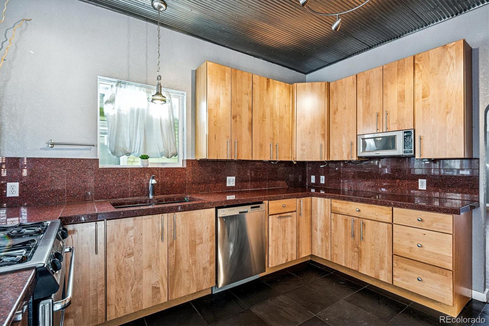 354 North Washington Street Denver, CO 80203 - Photo 15 of 43 a kitchen with stainless steel appliances a sink window and cabinets