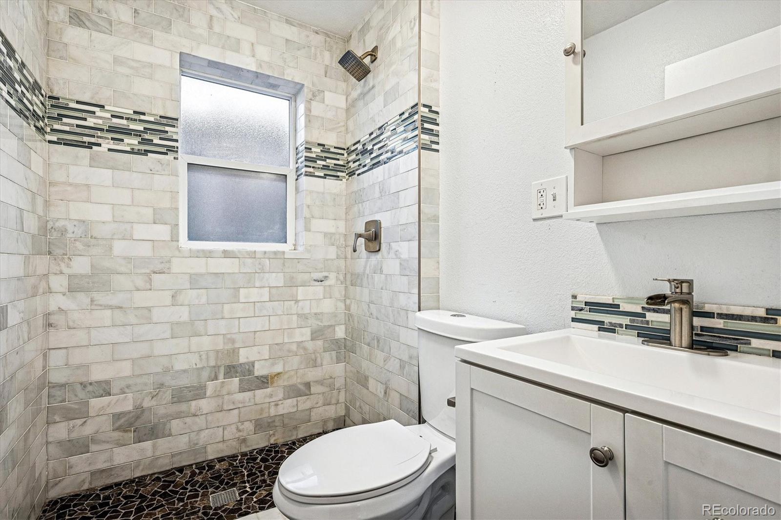 354 North Washington Street Denver, CO 80203 - Photo 25 of 43 a bathroom with a sink a toilet and shower