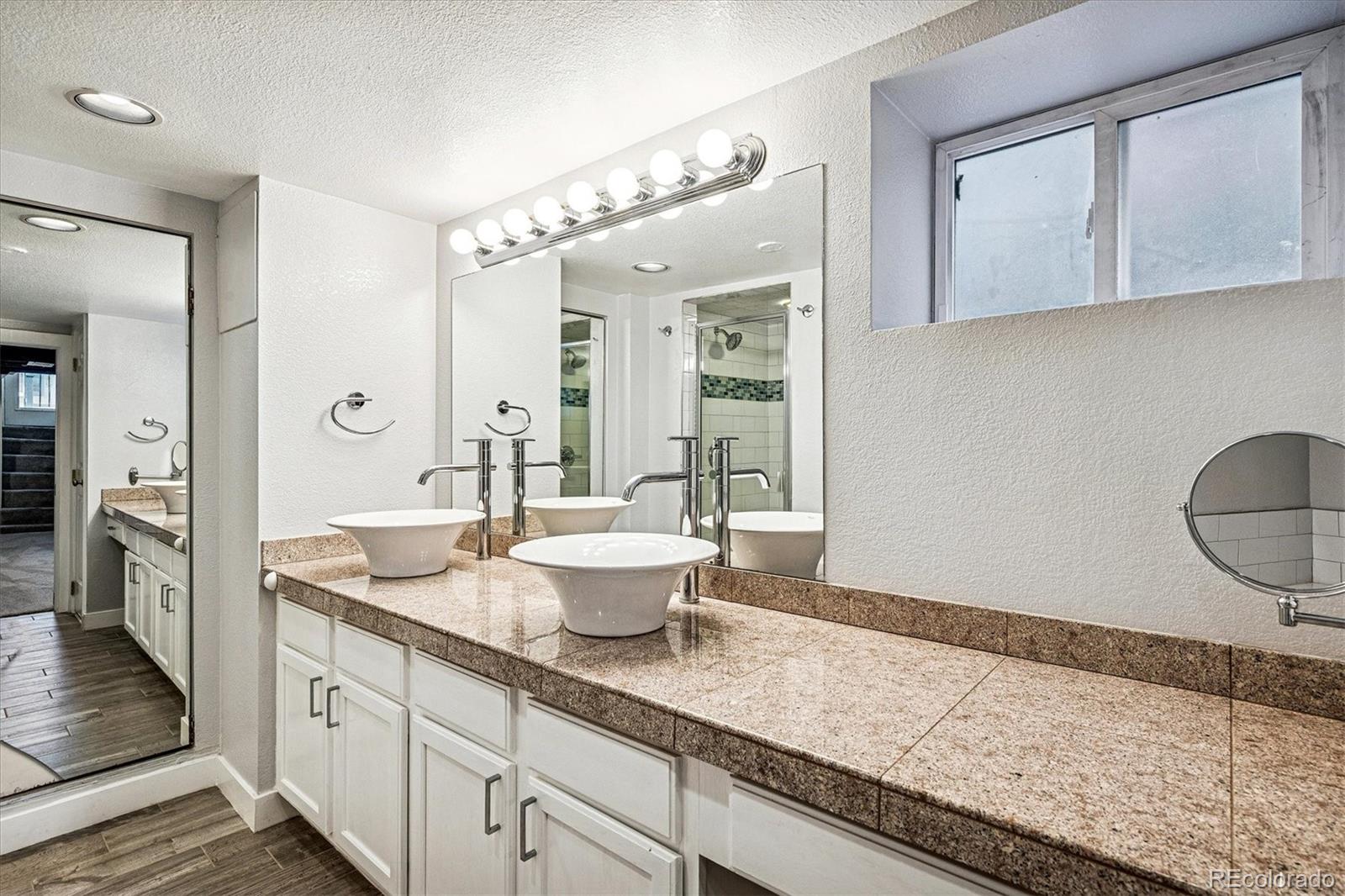 354 North Washington Street Denver, CO 80203 - Photo 32 of 43 a spacious bathroom with a granite countertop sink mirror and vanity