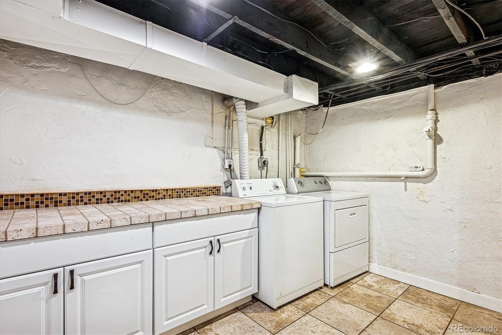 354 North Washington Street Denver, CO 80203 - Photo 35 of 43 a kitchen with white cabinets and sink