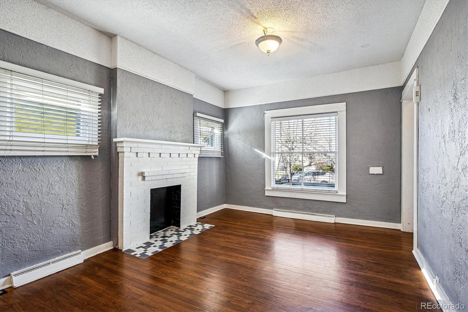 354 North Washington Street Denver, CO 80203 - Photo 10 of 43 an empty room with wooden floor fireplace and windows
