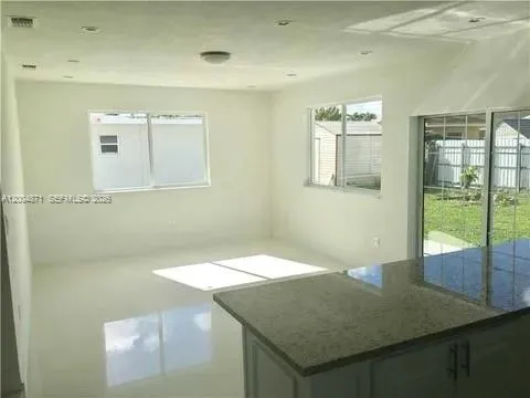 a view of a big room with windows and chandelier fan