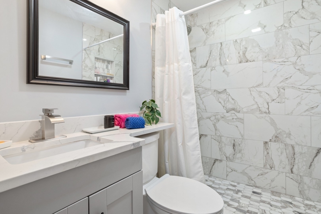 47 School Street Saugus, MA 01906 - Photo 13 of 30 a bathroom with a sink vanity mirror and toilet