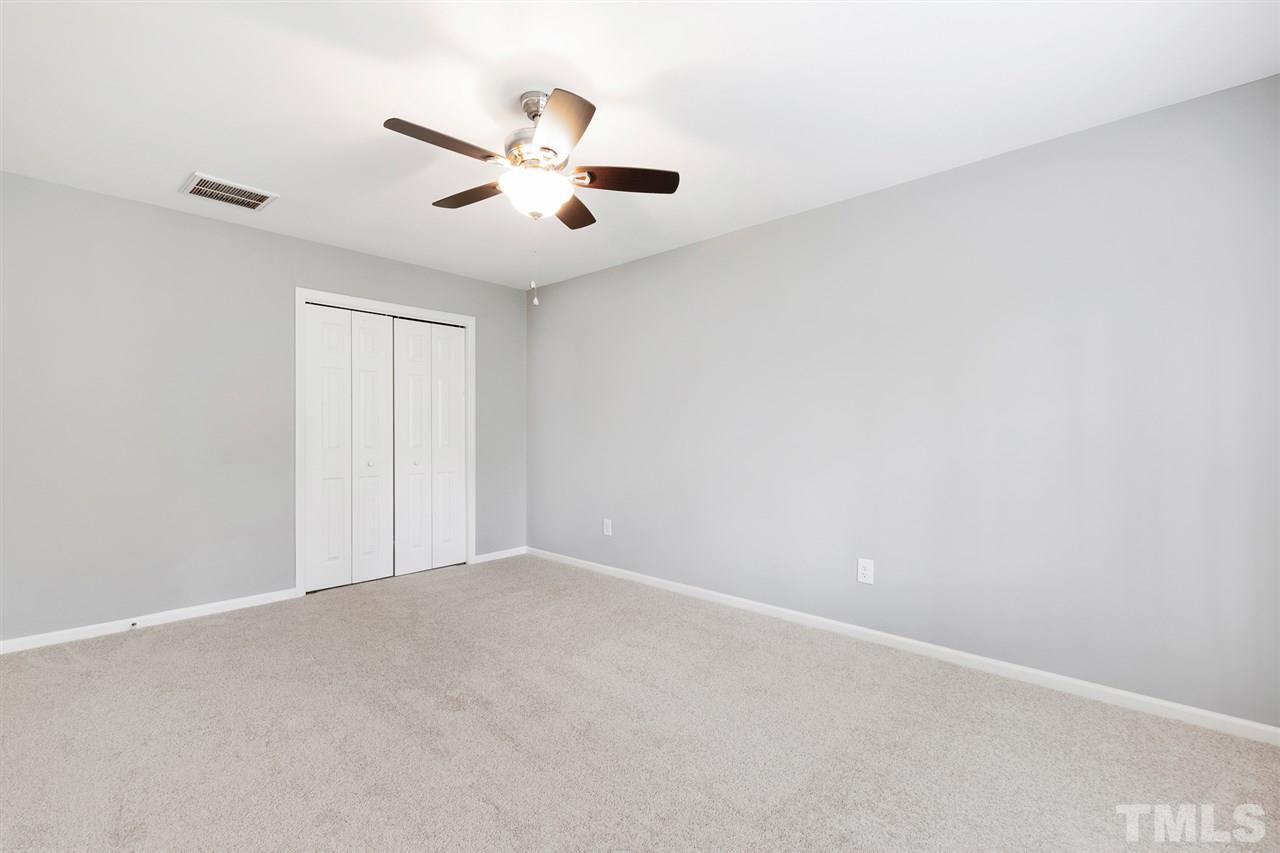 7605 Starling Court Raleigh, NC 27615 - Photo 19 of 30 an empty room with a window and a ceiling fan