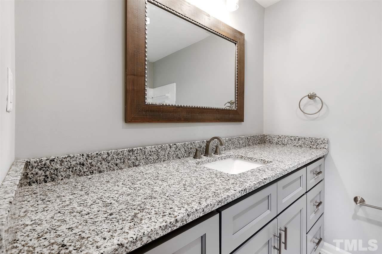 7605 Starling Court Raleigh, NC 27615 - Photo 23 of 30 a bathroom with a granite countertop sink and a mirror
