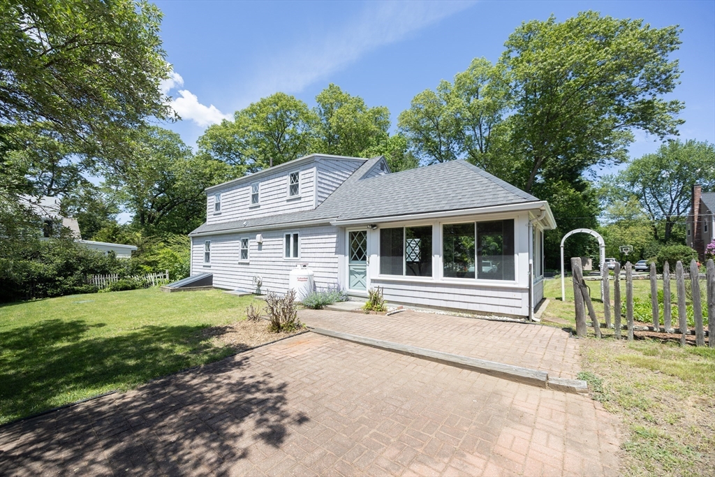 4 Cypress Road Natick, MA 01760 - Photo 7 of 32 a front view of a house with a yard table and chairs