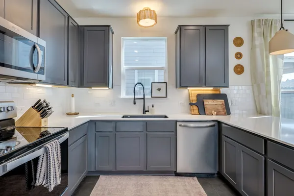 a kitchen with stainless steel appliances a sink a stove and cabinets