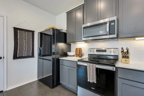 a kitchen with stainless steel appliances a stove microwave and refrigerator