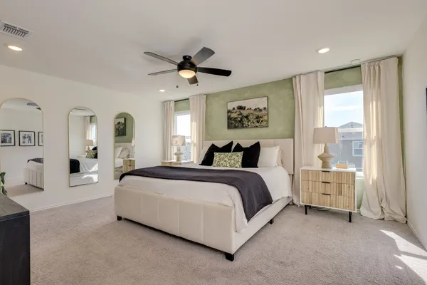 a spacious bedroom with a large bed and a chandelier