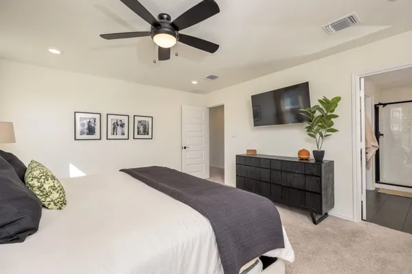 a bedroom with a bed window and a flat screen tv