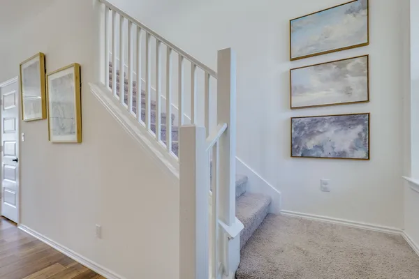 a view of staircase with wooden floor and white walls