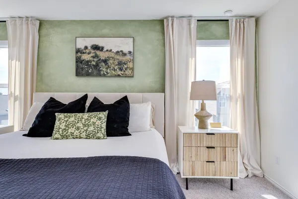 a bedroom with a bed and a painting on the wall