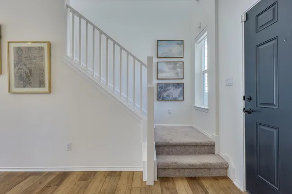 a view of staircase with white walls and a potted plant