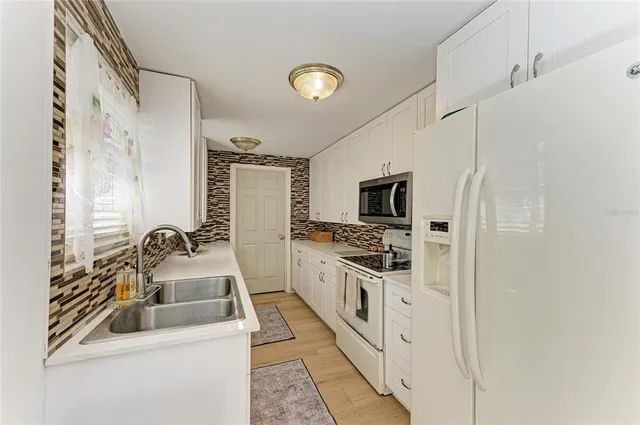 a kitchen with stainless steel appliances a sink a stove and a refrigerator