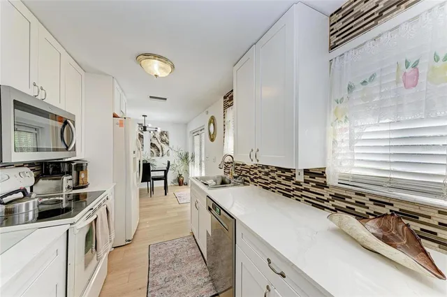 a kitchen with stainless steel appliances granite countertop a sink stove and cabinets