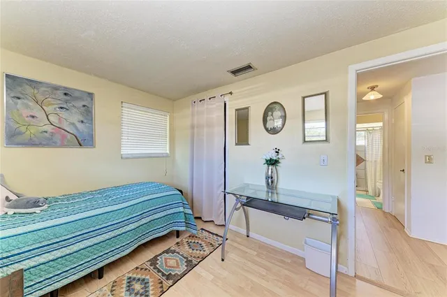 a bedroom with a bed and a table with wooden floor
