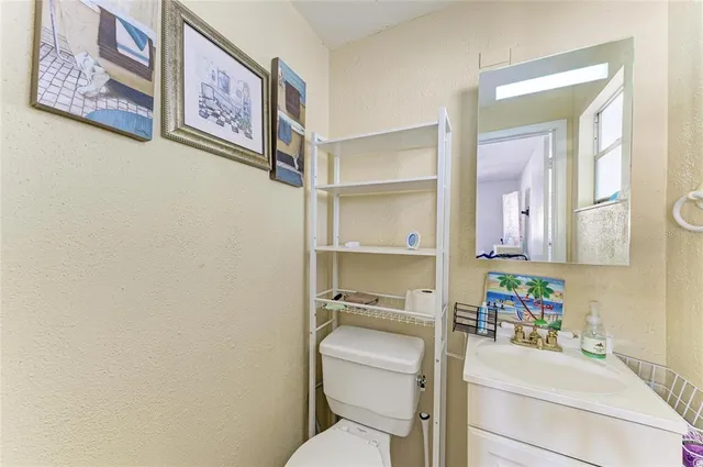 a bathroom with a toilet sink vanity and mirror