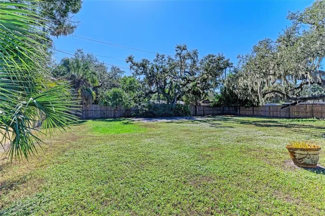 a view of yard with swimming pool and trees in the background
