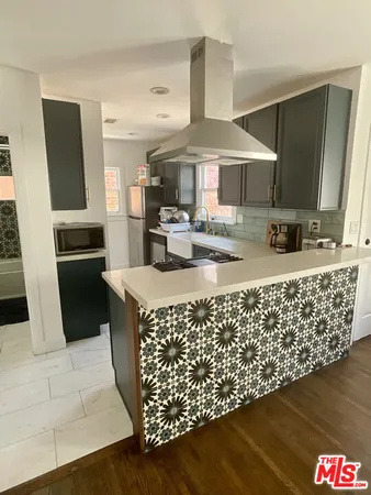 a kitchen with sink cabinets and wooden floor