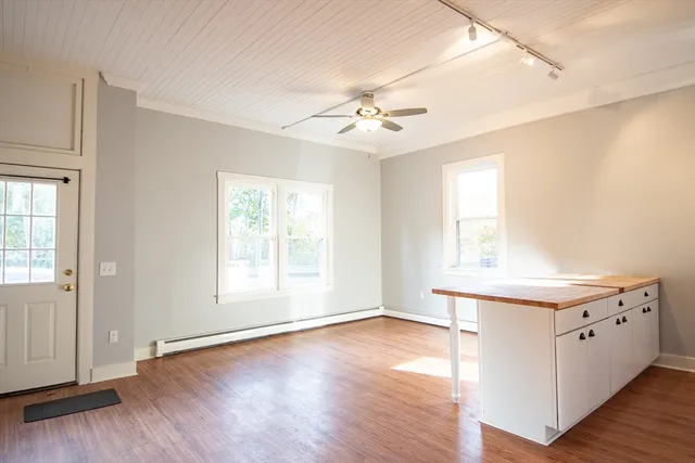 a view of an empty room with a window and wooden floor