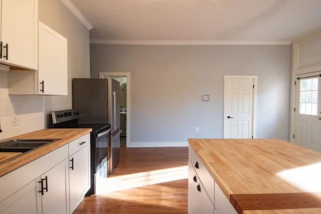 a kitchen with stainless steel appliances granite countertop a refrigerator and a stove