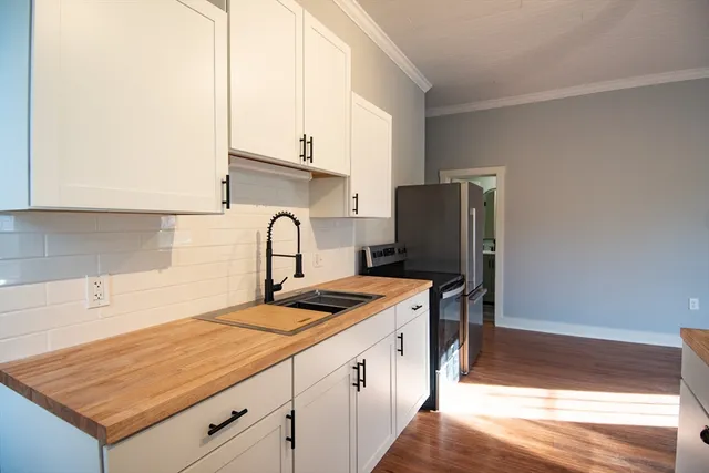 a kitchen with a sink a refrigerator and cabinets