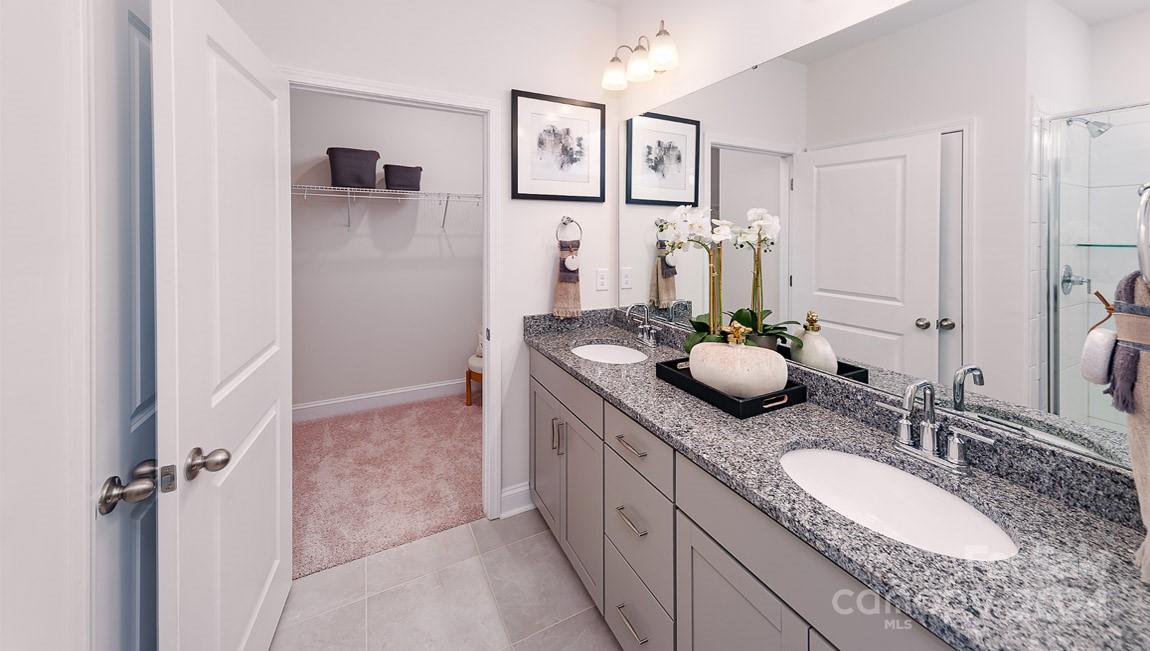 7870 Iron Road Sherrills Ford, NC 28673 - Photo 16 of 39 a bathroom with a granite countertop sink a mirror a vanity and a shower