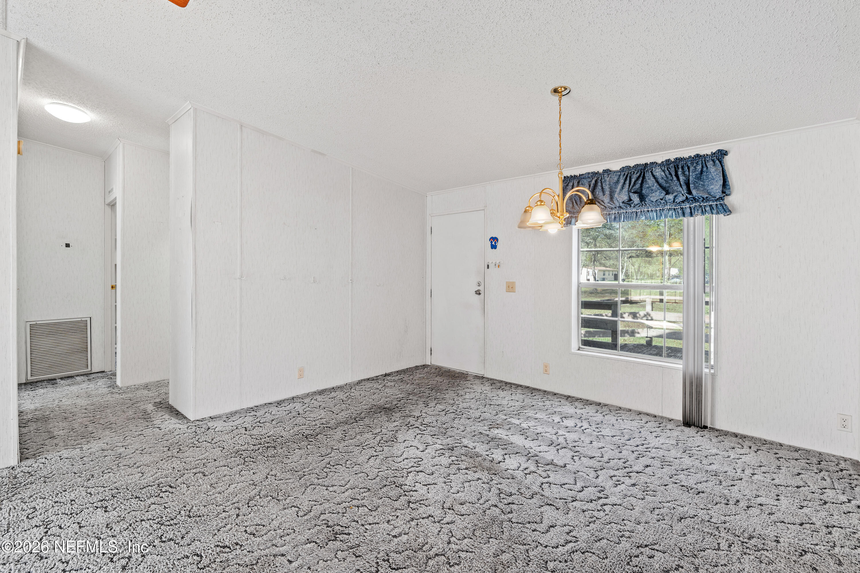 75026 Semper Fi Drive Yulee, FL 32097 - Photo 5 of 43 a view of an empty room with window and chandelier fan