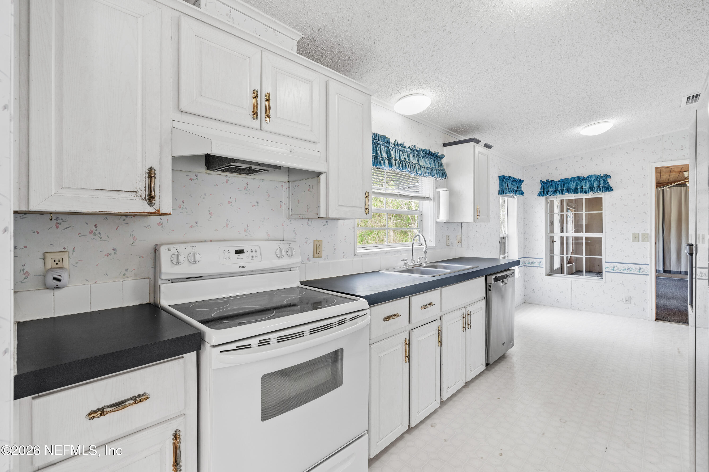 75026 Semper Fi Drive Yulee, FL 32097 - Photo 8 of 43 a kitchen with granite countertop white cabinets and white appliances