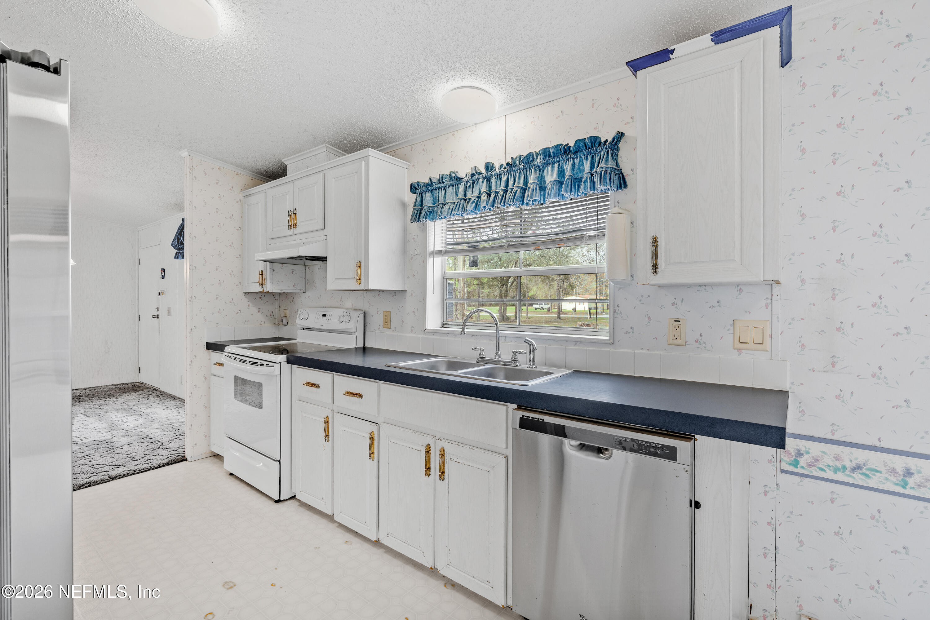 75026 Semper Fi Drive Yulee, FL 32097 - Photo 9 of 43 a kitchen with white cabinets and a sink
