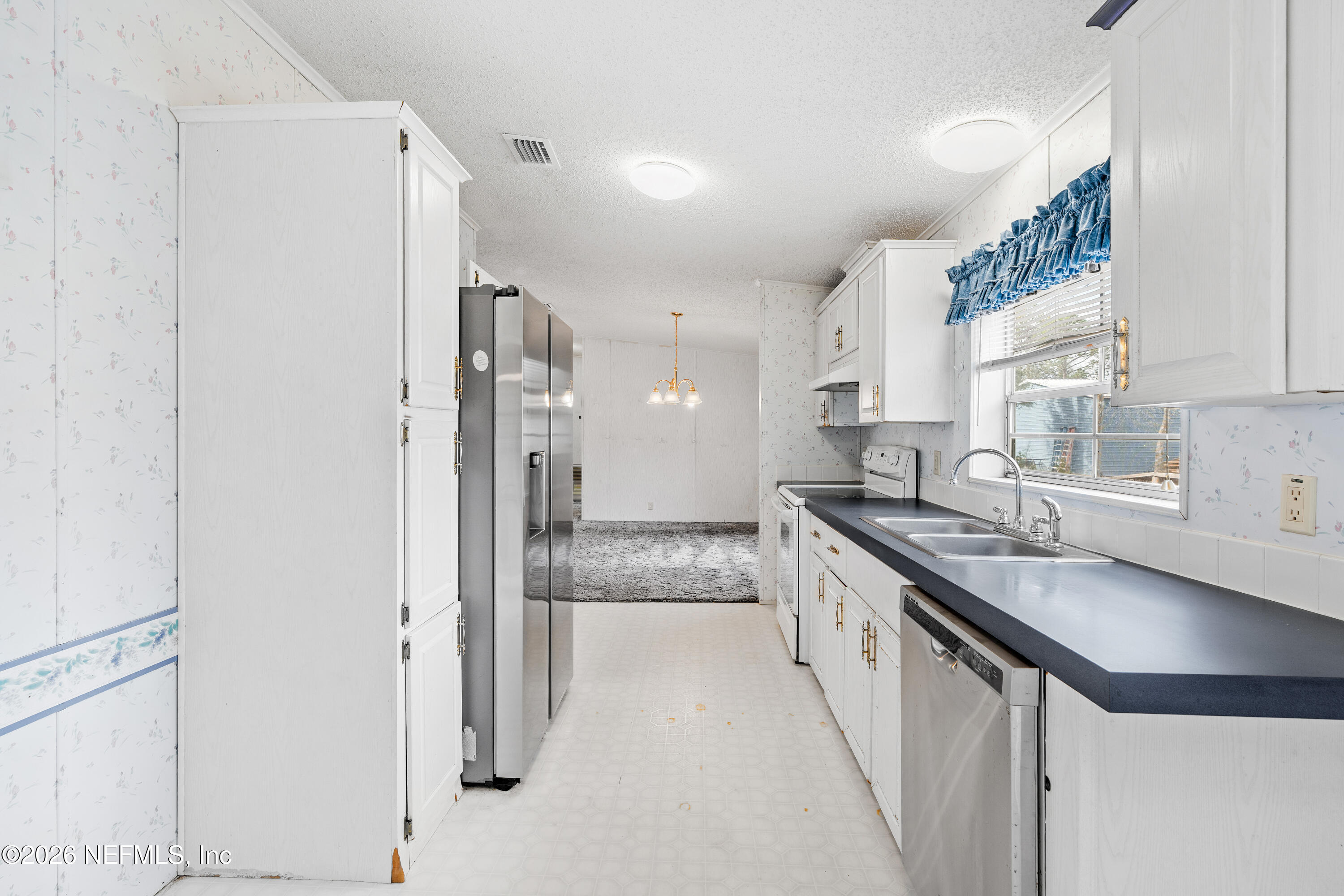 75026 Semper Fi Drive Yulee, FL 32097 - Photo 10 of 43 a kitchen with stainless steel appliances granite countertop a sink and a refrigerator