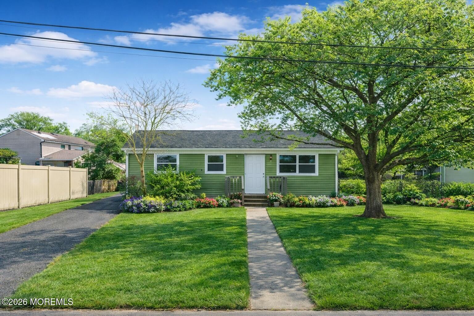 a front view of a house with a yard and trees