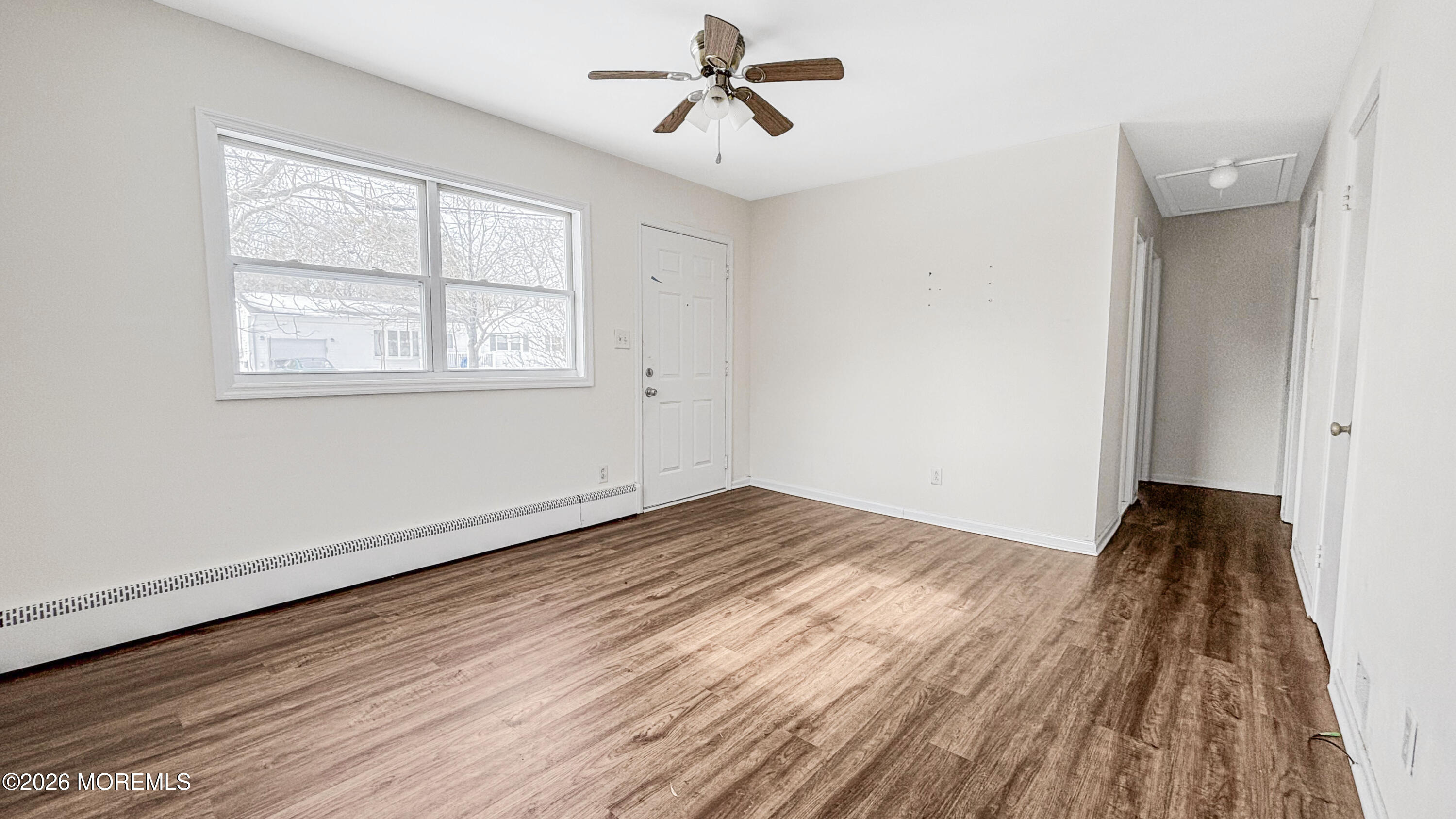385 Delaware Drive Brick, NJ 08723 - Photo 5 of 16 a view of empty room with wooden floor and fan