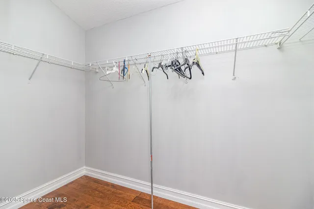 a spacious bedroom with a bed and wooden floor