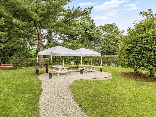 a view of a swimming pool with lawn chairs under an umbrella