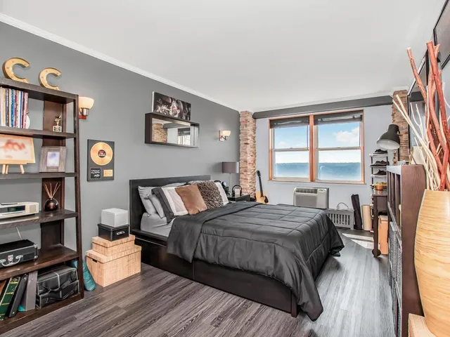 a bedroom with a bed wooden floor and a book shelf