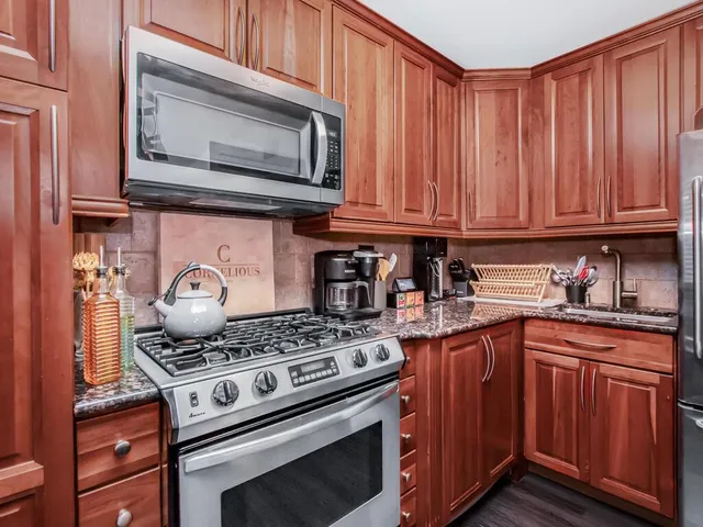 a kitchen with granite countertop a stove and a microwave