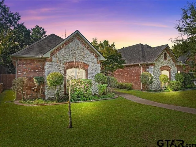 a view of a big house with a big yard and potted plants