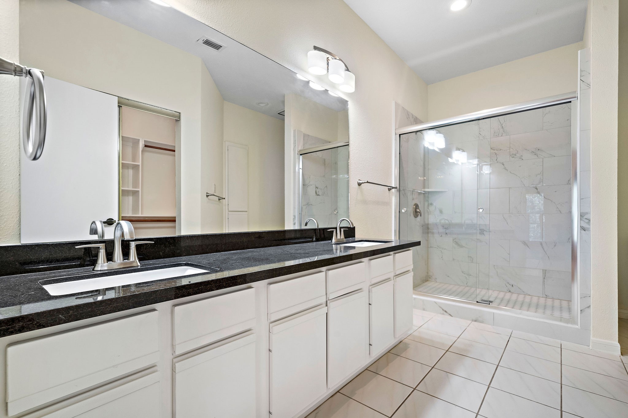 7941 Knight Road, Unit 20 Houston, TX 77054 - Photo 6 of 11 Renovated primary bath featuring dual vanities, granite countertops, and a beautifully updated walk-in shower.